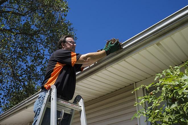 skilled laborer conducting repairs on a house's gutter in Cary IL